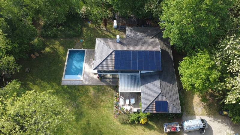 Installation photovoltaïque sur toiture ardoise en milieu boisé — vue drone d'ensemble, Gironde.