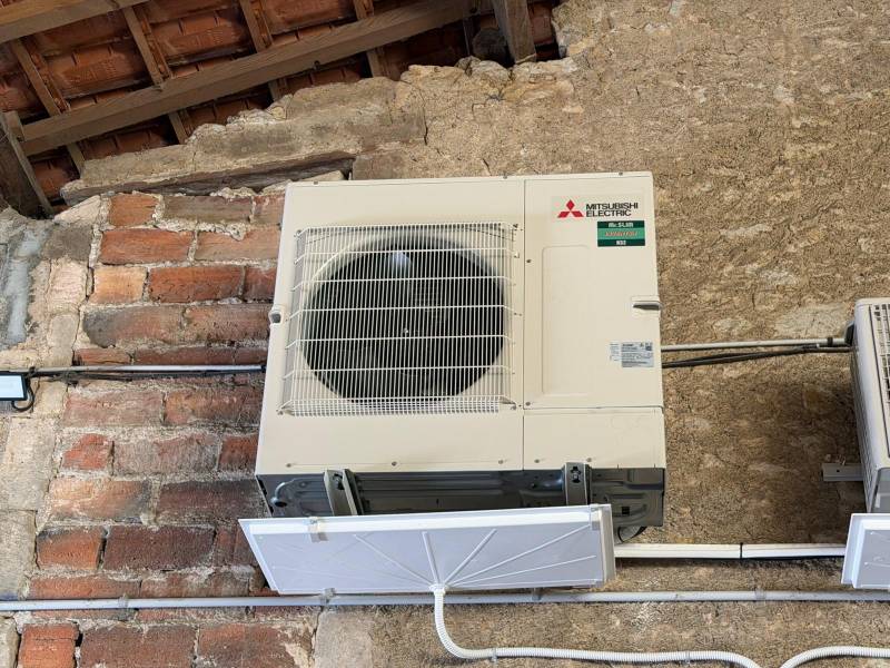 Unités extérieures pompe à chaleur Mitsubishi Mr.Slim R32 sur mur en pierre en Haute-Saintonge